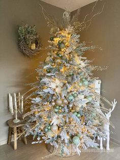 a white christmas tree with green and gold ornaments