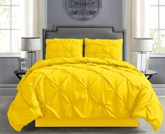 a bed with yellow comforter and pillows