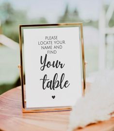 a table with a sign that says please locate your name and find your table