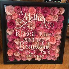 a framed artwork with pink and red paper roses on it, saying mother is like a flower each one beautiful day