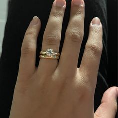 a close up of a person's hand with a diamond ring on their finger