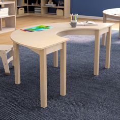 two children's table and chairs in a room with bookshelves on the wall