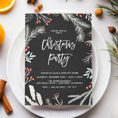 a black and white christmas party card sitting on top of a plate next to oranges