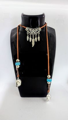 One long leather cord necklace with feathers and cowgirl hats and a little touch of turquoise. This necklace wraps around your neck to secure it Adjustable Bohemian Necklace For Rodeo, Adjustable Turquoise Necklace For Western-themed Events, Adjustable Brown Lariat Necklace For Festivals, Leather Cord Necklace, Cowgirl Hat, Leather Corded Necklace, Cowgirl Hats, New Market, Cord Necklace