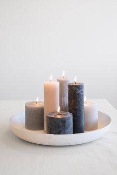 five candles are arranged on a white plate