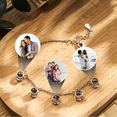 two pictures are attached to a chain on top of a wooden table with other items