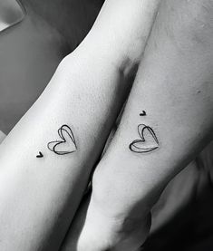 two people holding hands with tattoos on their arms and the words love are written in black ink