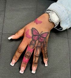 a woman's hand with pink and black butterflies on her left hand, while she has