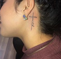 a woman with a small cross tattoo on her left side behind her ear and the word hope written in cursive font