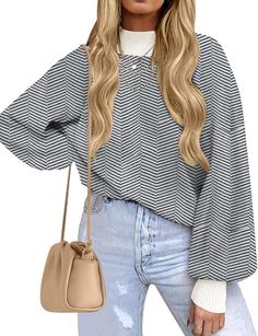 a woman with long blonde hair wearing a black and white striped top, jeans and a beige handbag