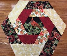 a close up of a patchwork quilt on a wooden table