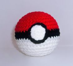 a crocheted poke ball is shown on a white surface with red and black accents