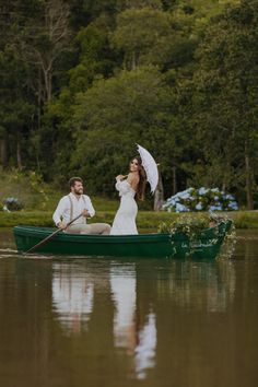 a man and woman in a green boat on the water