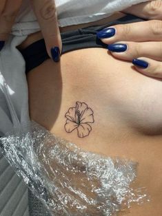 a woman's stomach with a flower tattoo on it