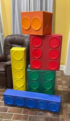 a stack of lego blocks sitting on top of a floor next to a brown chair