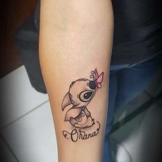 a small tattoo on the arm of a woman with an owl and name in it