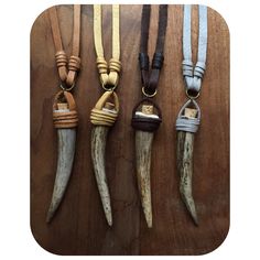 four different types of longhorn horns hanging on a wooden table with rope around them