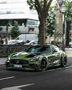 a green sports car is parked on the street