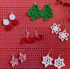 several crocheted earrings are displayed on a red tablecloth with white and green designs