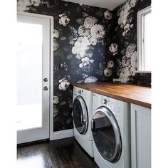 a washer and dryer in a room with floral wallpaper