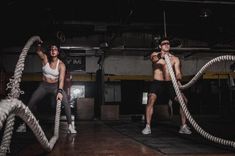 two men and a woman doing exercises with ropes