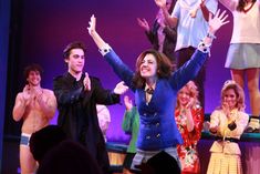 a group of people standing on top of a stage with their arms in the air