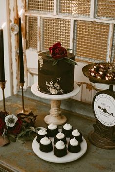 there is a chocolate cake and cupcakes on the table