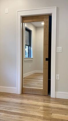 an empty room with wood floors and white walls