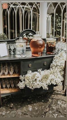 an old fashioned bar with flowers and glasses on it