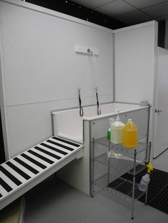 a room with white walls and black and white lines on the floor, two bottles of yellow liquid are sitting next to each other