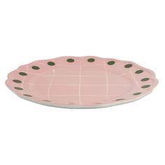 a pink plate with green dots on it