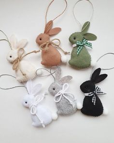 four small stuffed bunnies in different colors and sizes, tied together with twine string