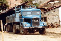 an old blue truck parked in front of a building