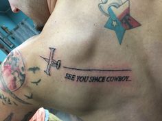 a man with a tattoo on his back saying see you space cowboy and an airplane