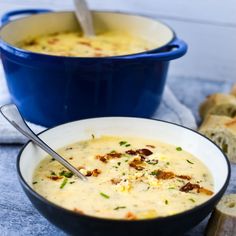 two bowls of soup with bread on the side