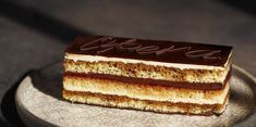 a piece of cake sitting on top of a metal plate with the word happy written on it