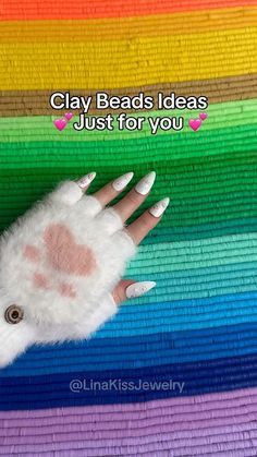 a person's hand with white nails and fake fur on it