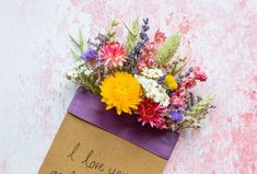 a bouquet of wildflowers in a card saying i love you