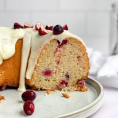 a cake with white icing and cranberries on a plate