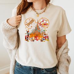 a woman wearing a disneyland tshirt with mickey mouse ears and castle on it