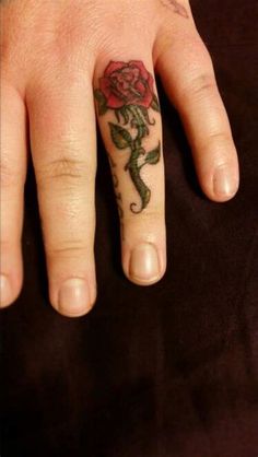 a person with a rose tattoo on their left hand and the other half of her finger