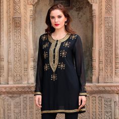 Sandip Agarwal of India designs this semi-sheer black polyester tunic that sparkles with hand embroidered embellishments. The hem sleeves and neckline are embroidered with alternating rows of gold-toned elongated faceted beads and round beads. The same beaded motif carries down the front of the tunic ending in a deep V. On the end of each sleeve on the center back and across the front are embroidered flowers embellished with beads and sequins. Luxury Embellished Tunic For Festive Season, Luxury Long Sleeve Tunic With Embroidered Neckline, Luxury Long Sleeve Embroidered Tunic, Luxury Dabka Embellished Women's Tunic, Luxury Embroidered Neckline Tunic For Eid, Luxury Long Sleeve Embellished Tunic, Luxury Embroidered V-neck Tunic, Luxury Resham Embroidery Festive Tunic, Maroon Gowns