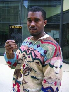 a man in a colorful sweater holding up a card