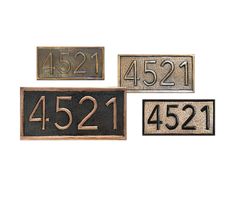 three metal address signs with numbers on them