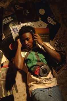 a man laying on the floor with headphones in his ears and listening to music