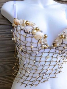 a white mannequin with gold and pearls on it