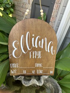 a wooden sign hanging from the side of a planter that says elliana and true date time