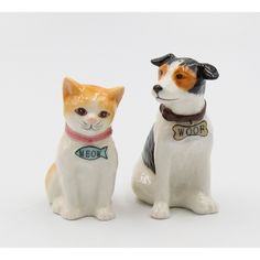 two ceramic figurines of dogs with collars and name tags on their necks