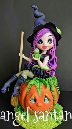 a figurine sitting on top of a pumpkin with a witch hat and broom