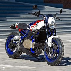 a white and blue motorcycle parked in front of some steps